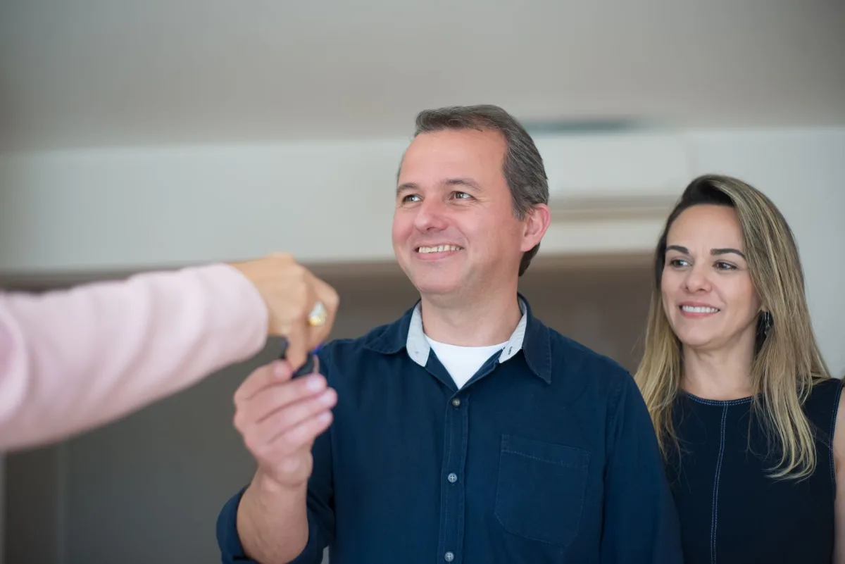 Casal recebendo as chaves da nova casa